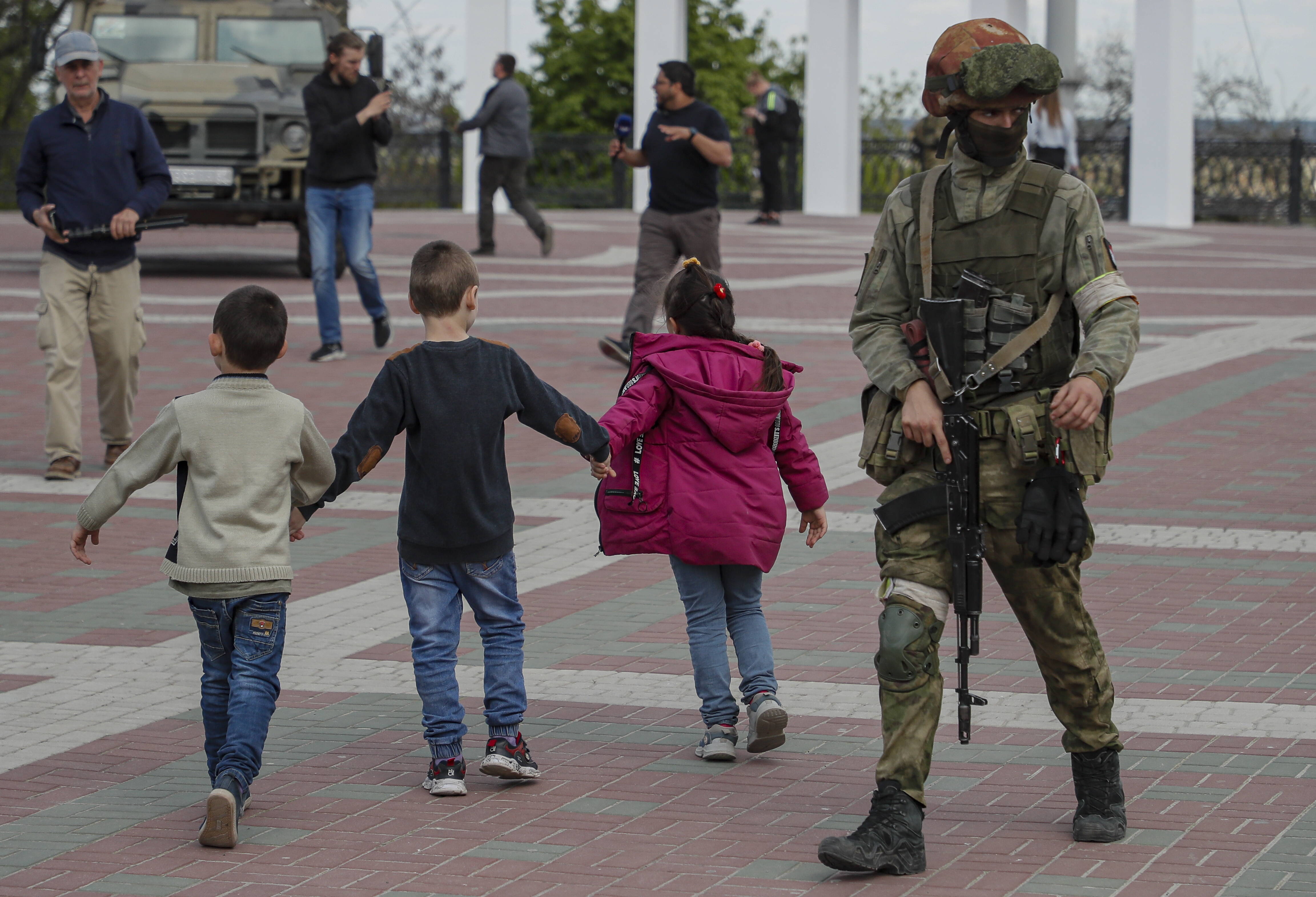 Діти та російський солдат в окупованому Маріуполі. Fot. PAP/EPA/SERGEI ILNITSKY