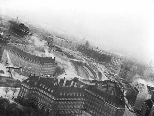 21 marca 1945 r., Kopenhaga. Jeden z 20 samolotów Mosquito przelatuje tuż nad dachami budynków w trakcie  operacji „Carthage” – nalotu na siedzibę gestapo, gmach Shellhuset przy Kampmannsgade. Fot. Domena publiczna