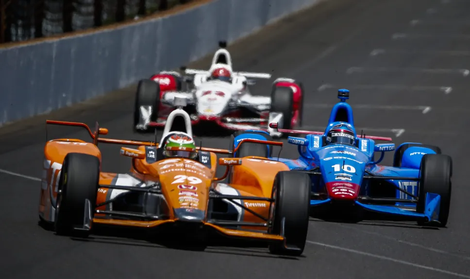 Simona De Silvestro ze Szwajcarii (z lewej) wyprzedza Tony’ego Kanaana z Brazylii (z prawej) i Simona Pagenauda z Francji (w środku) na pierwszym zakręcie 99. edycji wyścigu samochodowego Indianapolis 500 na torze Indianapolis Motor Speedway w Indianapolis. Fot. PAP/EPA/TANNEN MAURY