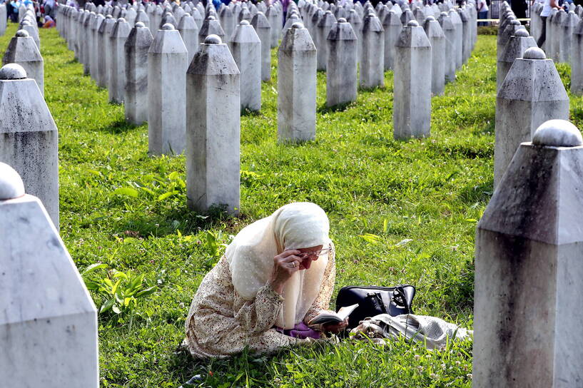 Muzułmanka podląca się nad jednym z grobów w Srebrenicy, fot. PAP/EPA/FEHIM DEMIR
