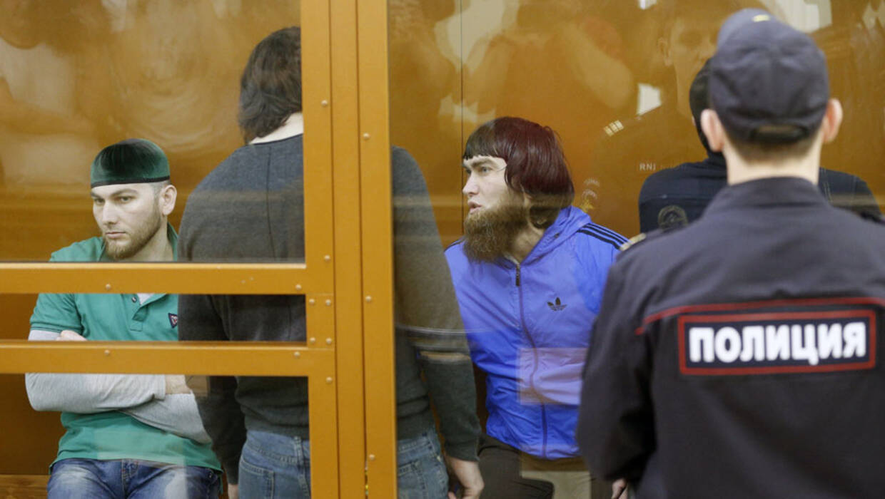 epa06052338 Defendants in Boris Nemtsov murder case, Shadid Gubashev (L), Zaur Dadayev (2-L, standing back to camera) and Anzor Gubashev (3-L), are seen inside a glass-walled cage during a hearing at the Moscow district military court in Moscow, Russia, 27 June 2017. Russian opposition leader Boris Nemtsov was shot dead from a passing car on the Bolshoy Kammeny bridge near the Kremlin on 27 February 2015.  Fot. PAP/EPA/SERGEI CHIRIKOV 