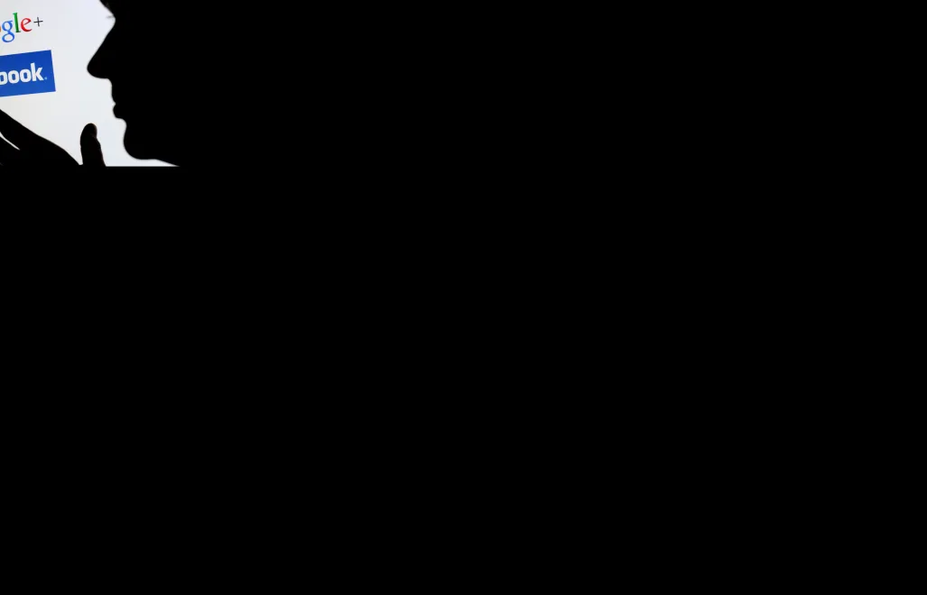 Profil osoby przed monitorem oraz logo Facebook i Google Fot. PAP/ EPA / JULIAN STRATENSCHULTE