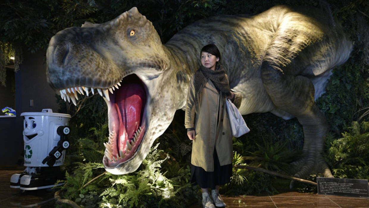 Młoda kobieta pozuje do naturalnej wielkości tyranozaura w holu wejściowym podczas pokazu prasy w hotelu `` Henn na Hotel '' lub `` Weird Hotel '' w Urayasu, na wschód od Tokio, Japonia Fot. PAP/ EPA / FRANCK ROBICHON