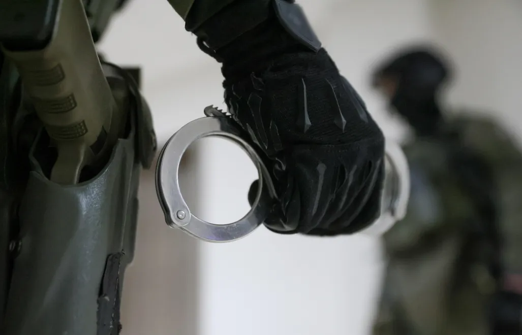 Funkcjonariusz CBŚP trzymający kajdanki - zdjęcie ilustracyjne. Fot. PAP/Leszek Szymański