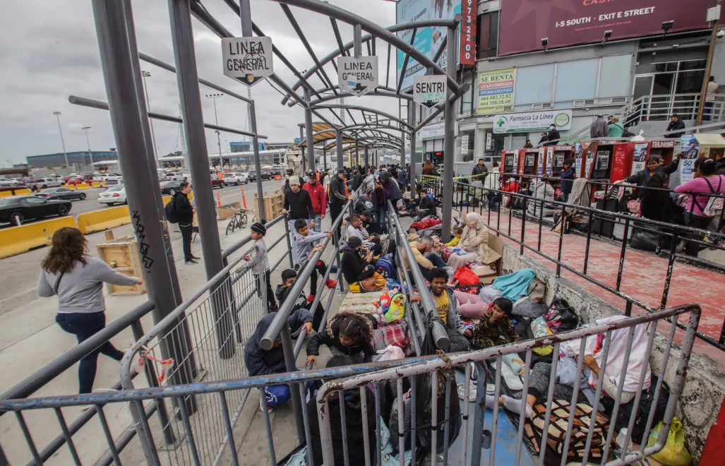 Мигранты разных национальностей отдыхают у входа на пешеходный контрольно-пропускной пункт Сан-Исидро, чтобы попросить убежища у властей США в Тихуане, Мексика Fot. PAP/EPA/Joebeth Terriquez