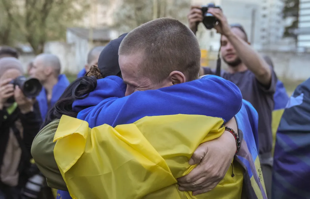 Українські військовополонені зустрічаються зі своїми родичами та друзями після обміну полоненими у невідомому місці в Україні. Fot. PAP/EPA/STRINGER