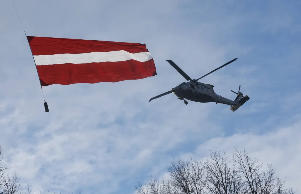 Śmigłowiec UH-60M Black Hawk Łotewskich Sił Powietrznych i flaga narodowa Fot. PAP/EPA/TOMS KALNINS