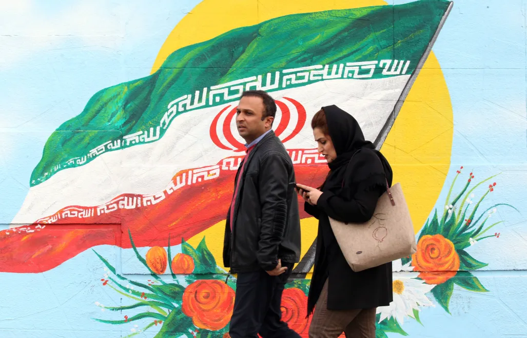 Irańska kobieta spoglądająca w telefon. Fot EPA/ABEDIN TAHERKENAREH