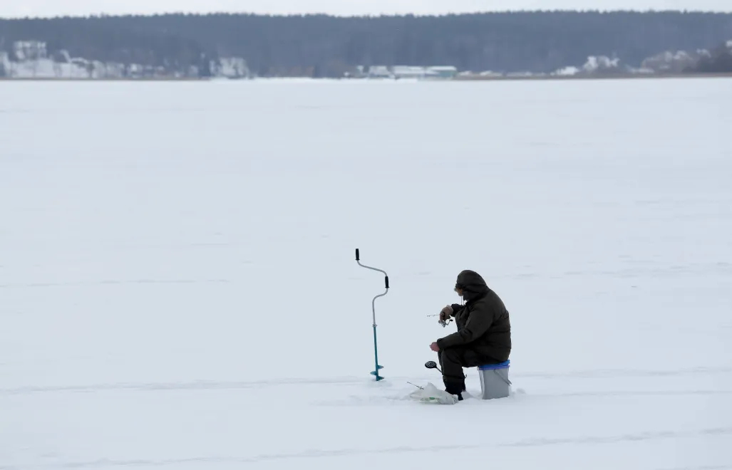 Wędkarz podlodowy na zamarzniętym jeziorze Niegocin Fot. PAP/Tomasz Waszczuk