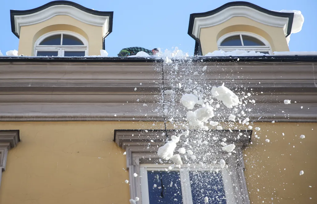 Spadający z dachu budynku śnieg. Fot. PAP/Łukasz Gągulski