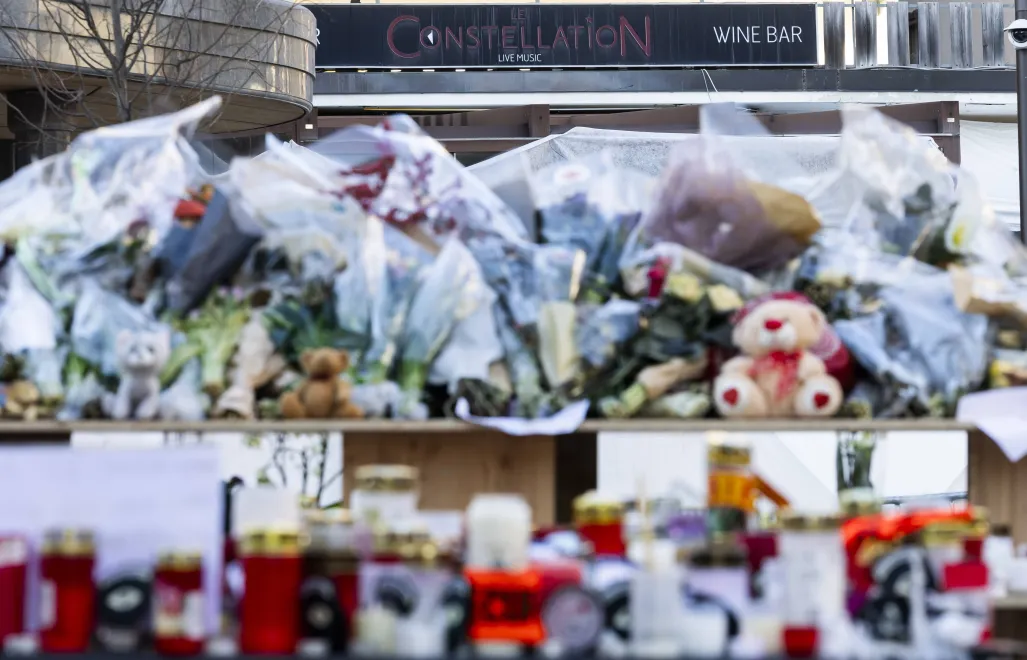 Kwiaty i znicze na miejscu tragedii w barze w Crans-Montanie w Szwajcarii Fot. PAP/EPA/CYRIL ZINGARO 