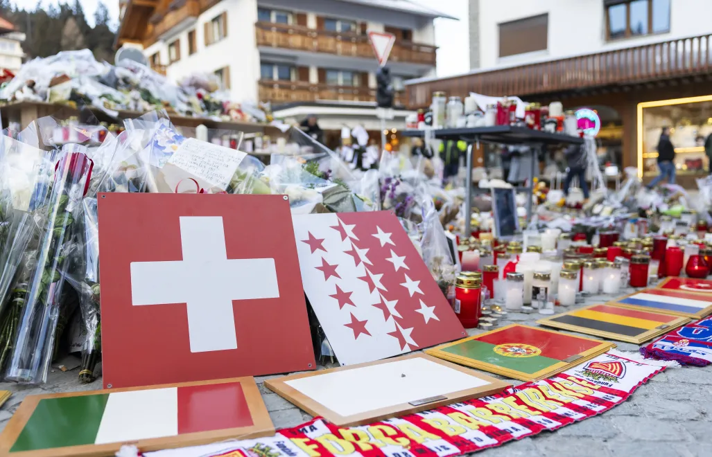 Kwiaty i znicze w hołdzie ofiarom przed barem w Crans-Montanie, fot. PAP/EPA/KEYSTONE/CYRIL ZINGARO