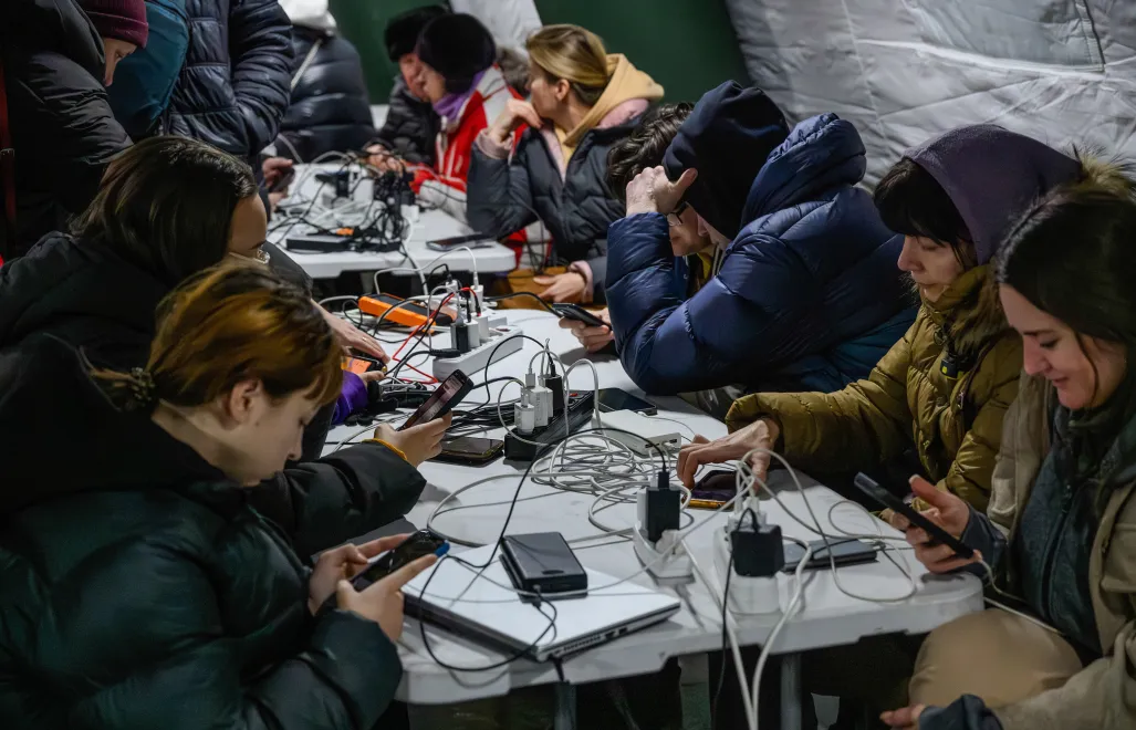 Mieszkańcy Kijowa gromadzą się w ogrzewanym namiocie, w którym można także dodładować urządzenia elektroniczne. Fot. PAP/Vladyslav Musiienko