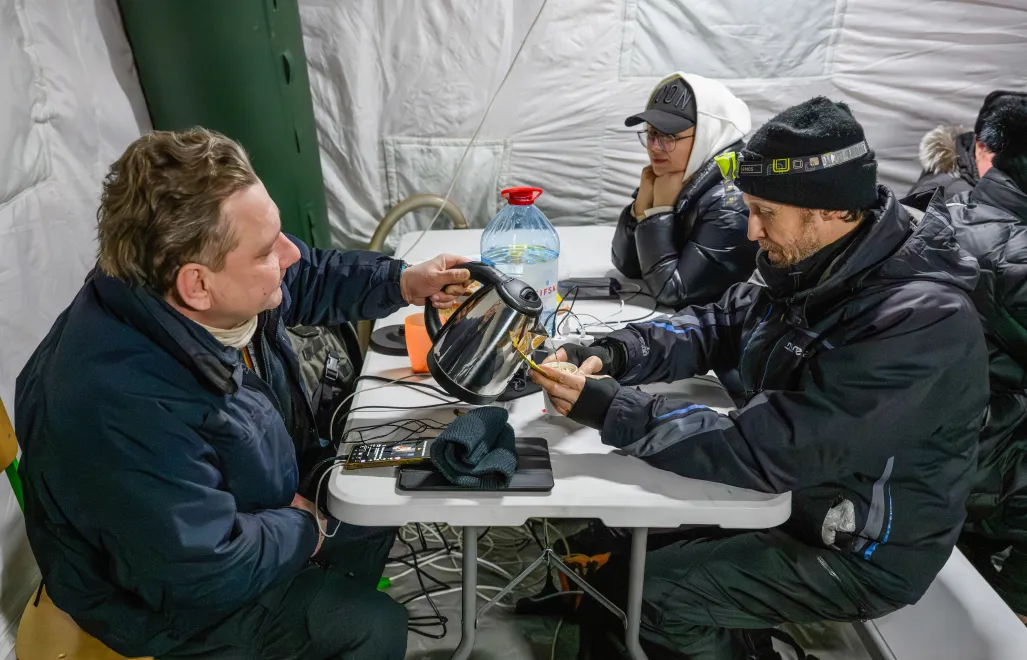 Mieszkańcy Kijowa gromadzą się w ogrzewanym namiocie, w którym można także dodładować urządzenia elektroniczne. Fot. PAP/Vladyslav Musiienko