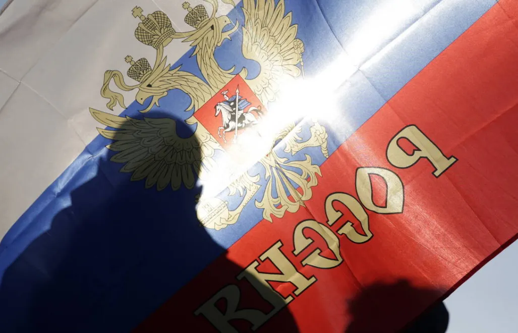 Тінь чоловіка на фоні російського прапора. Фотоілюстрація. Fot. PAP/EPA/ANDREJ CUKIC