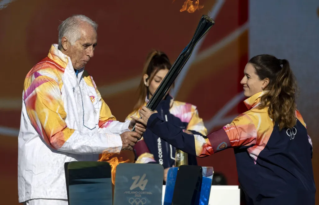 Giovanni Malago trzyma pochodnię z płomieniem olimpijskim podczas sztafety z pochodnią na Igrzyska Olimpijskie Mediolan-Cortina 2026 Fot. PAP/EPA/MASSIMO PERCOSSI