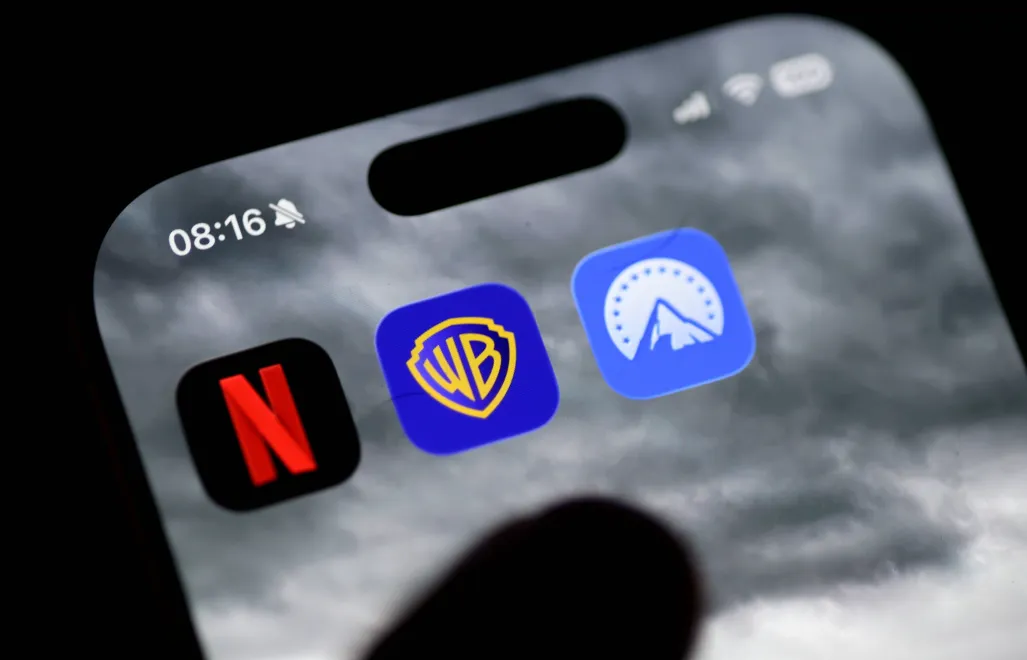 Logo Netflixa, Warner Bros. i Paramount na ekranie smartfona, fot. PAP/EPA/HANNIBAL HANSCHKE