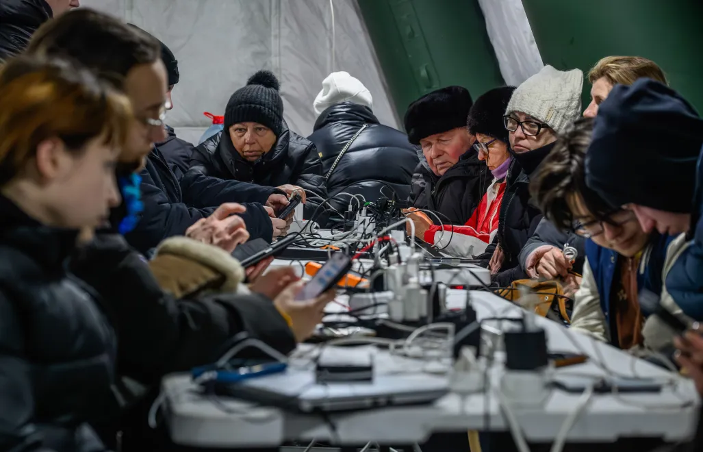 ieszkańcy Kijowa gromadzą się w ogrzewanym namiocie, w którym można także dodładować urządzenia elektroniczne. Fot. PAP/Vladyslav Musiienko