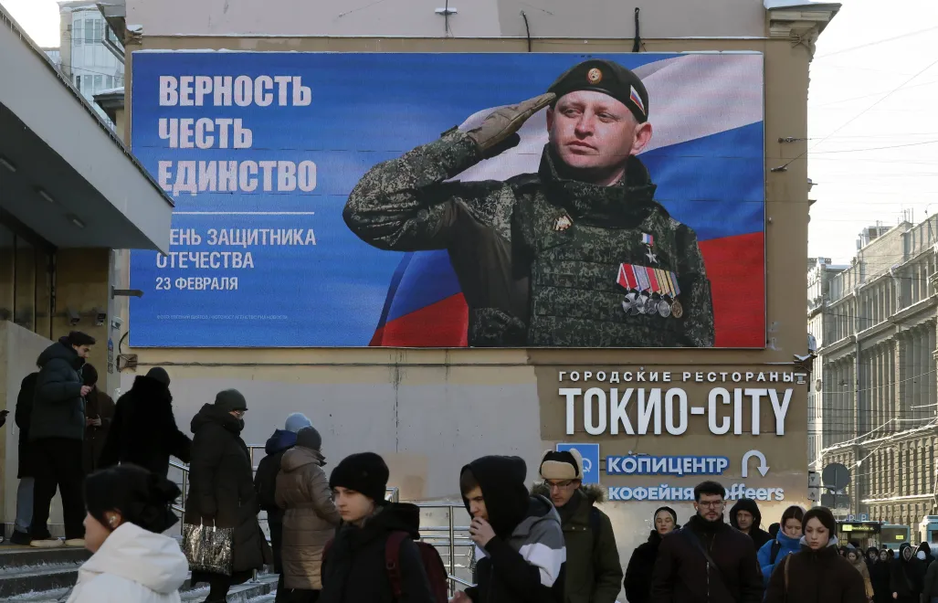 Ludzie przechodzą obok billboardu podczas „Dnia Obrońcy Ojczyzny” w Petersburgu w Rosji Fot. PAP/EPA/ANATOLY MALTSEV