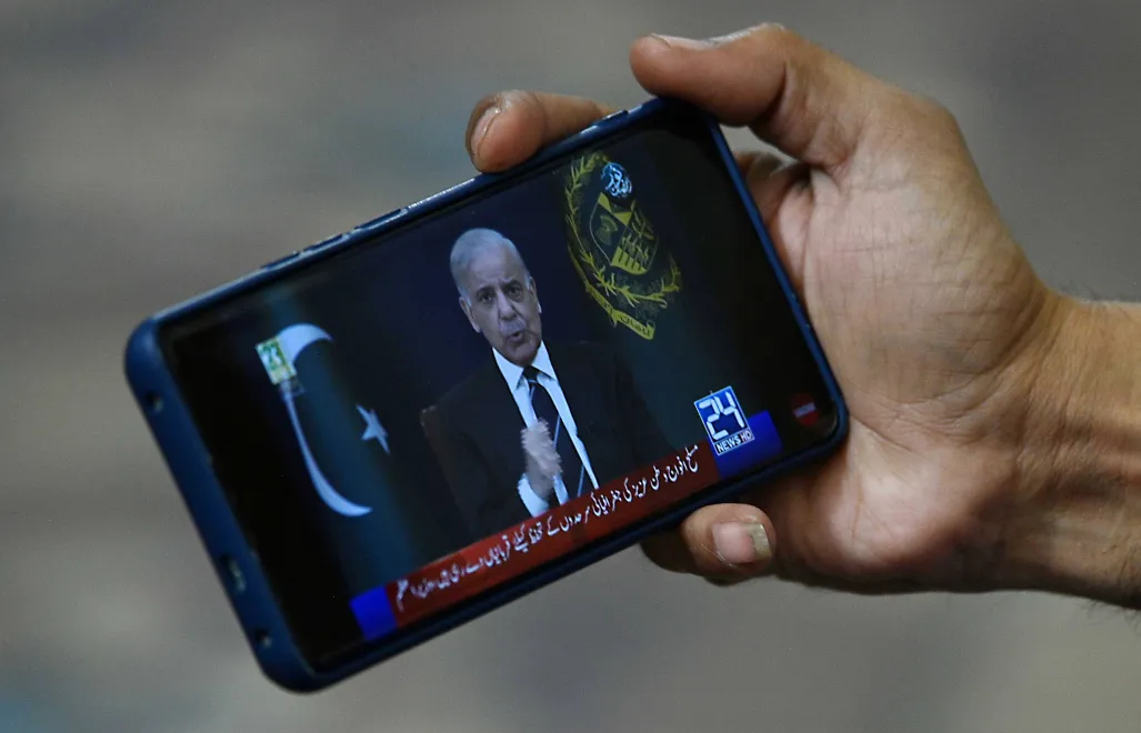 Telefon z wyświetlonym przemówieniem premiera Pakistanu Shehbaza Sharifa. Fot PAP/EPA/SHAHZAIB AKBER 