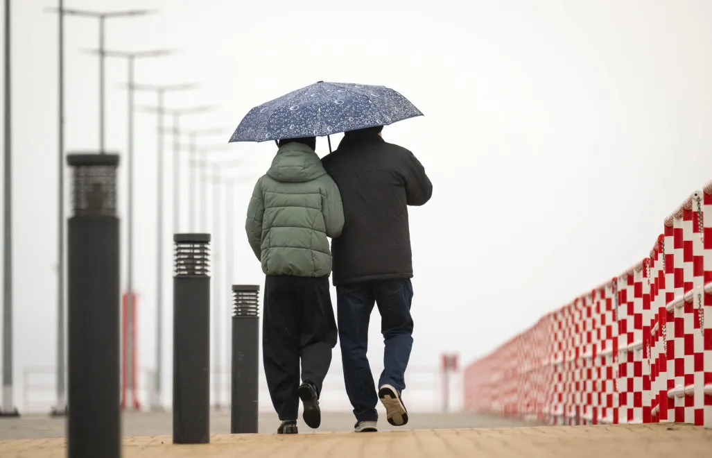 Spacer pod parasolem. Bulwar Słoneczny w Krynicy Morskiej. Fot. PAP/Tytus Żmijewski