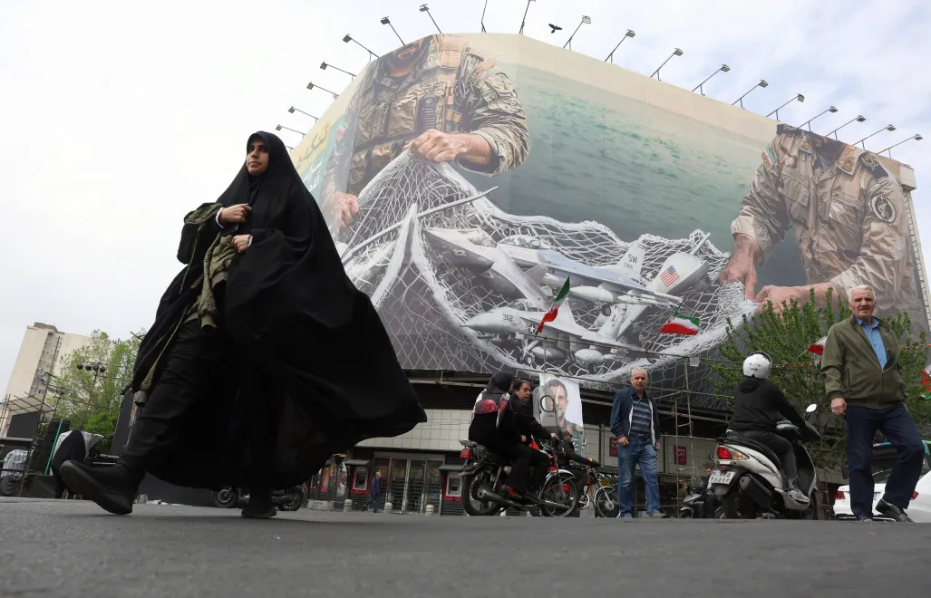 Kobieta idzie obok antyamerykańskiego billboardu w Teheranie z napisem „Cieśnina Ormuz pozostanie zamknięta” Fot. PAP/EPA/ABEDIN TAHERKENAREH