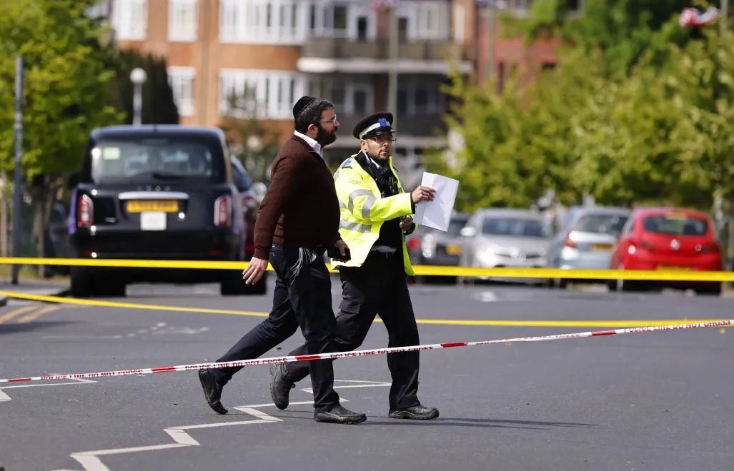 Policjant i członek społeczności żydowskiej na miejscu zdarzenia, fot. PAP/EPA/TOLGA AKMEN