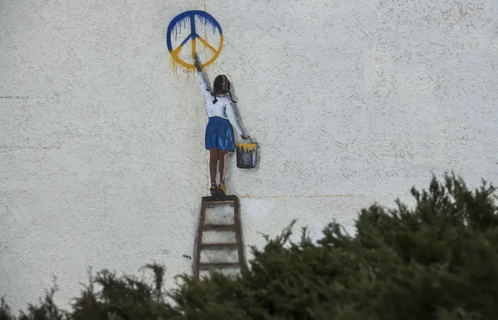 Graffiti autorstwa włoskiego artysty TV Boya na murze budynku w Buczy. Fot. PAP/	Vladyslav Musiienko
