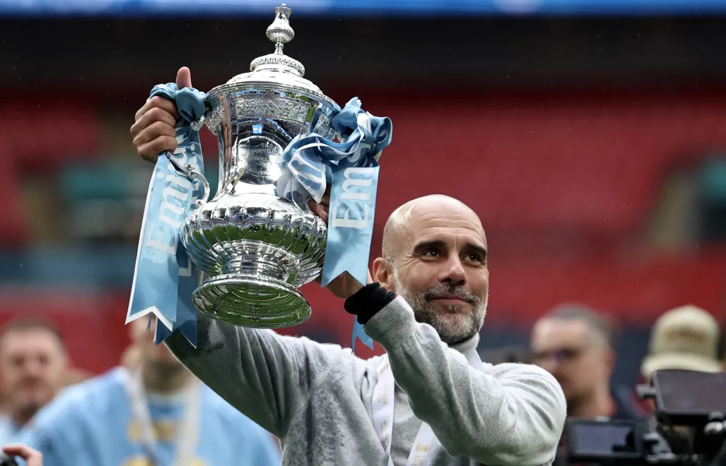 Guardiola celebrujący zdobycie swojego ostatniego trofeum jako trener Manchesteru City, angielskiego FA Cup, fot. PAP/EPA/NEIL HALL