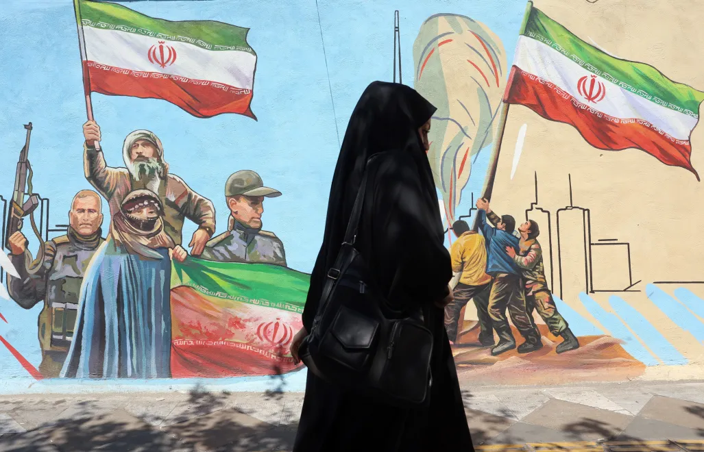 Zamaskowana Iranka przechodzi obok muralu na ulicy w Teheranie Fot. PAP/EPA/ABEDIN TAHERKENAREH
