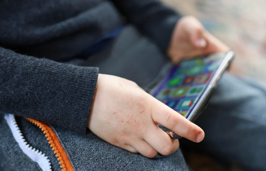 Smartfon w rękach dziecka - zdjęcie ilustracyjne. Fot. PAP/Szymon Pulcyn