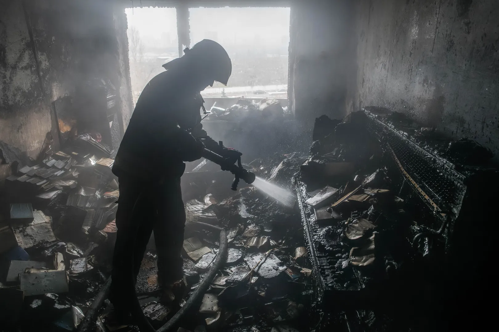 Пожежник гасить пожежу в повністю обгорлій квартирі після російського удару. Фотоілюстрація. Fot. PAP/	Vladyslav Musiienko 