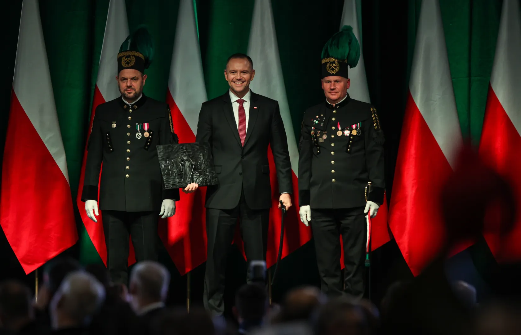 Prezydent RP Karol Nawrocki (C), prezes Zarządu Polskiej Grupy Górniczej S.A. Łukasz Deja (L) oraz dyrektor KWK „Staszic-Wujek” Marek Okoń (P) podczas uroczystej Akademii Barbórkowej KWK „Staszic-Wujek” Fot. PAP/Jarek Praszkiewicz