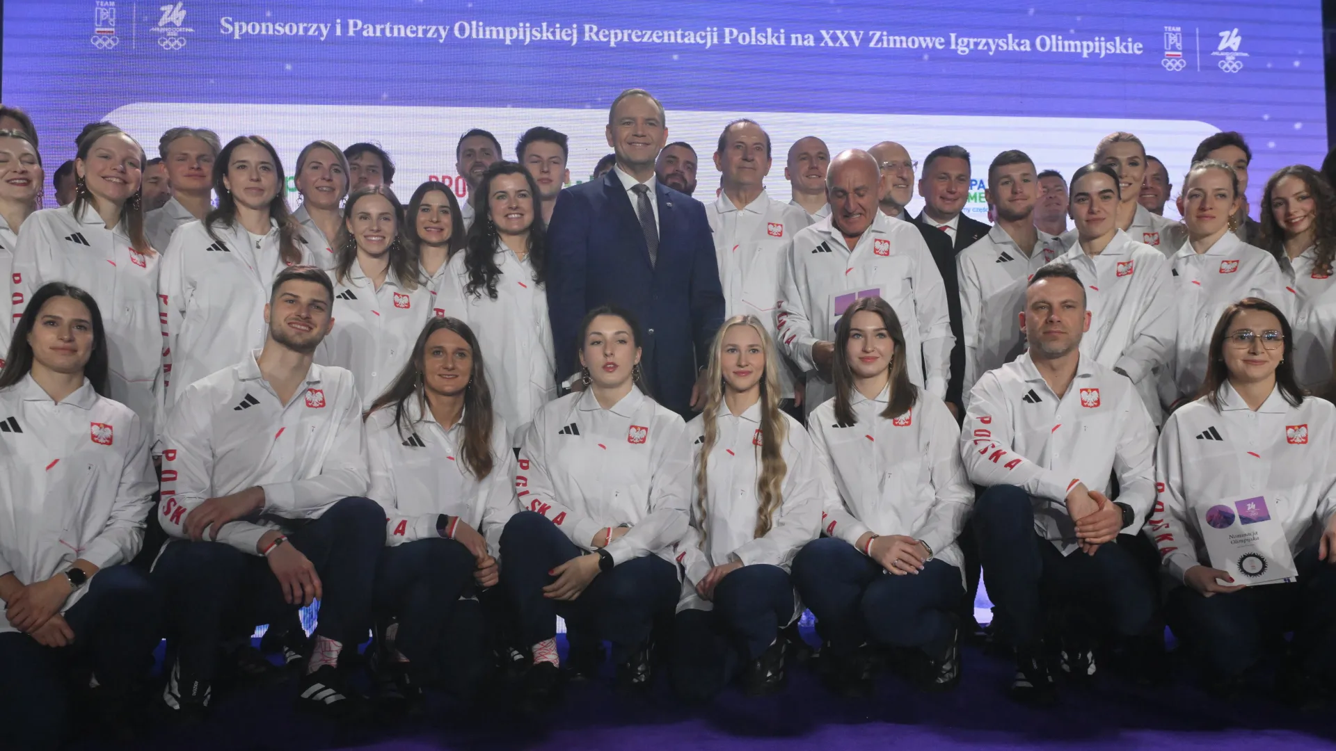 rezydent RP Karol Nawrocki (C) pozuje do zdjęcia z olimpijską reprezentacją Polski podczas ceremonii ślubowania i wręczenia nominacji na XXV Zimowe Igrzyska Olimpijskie Mediolan-Cortina 2026 Fot. PAP/Piotr Nowak