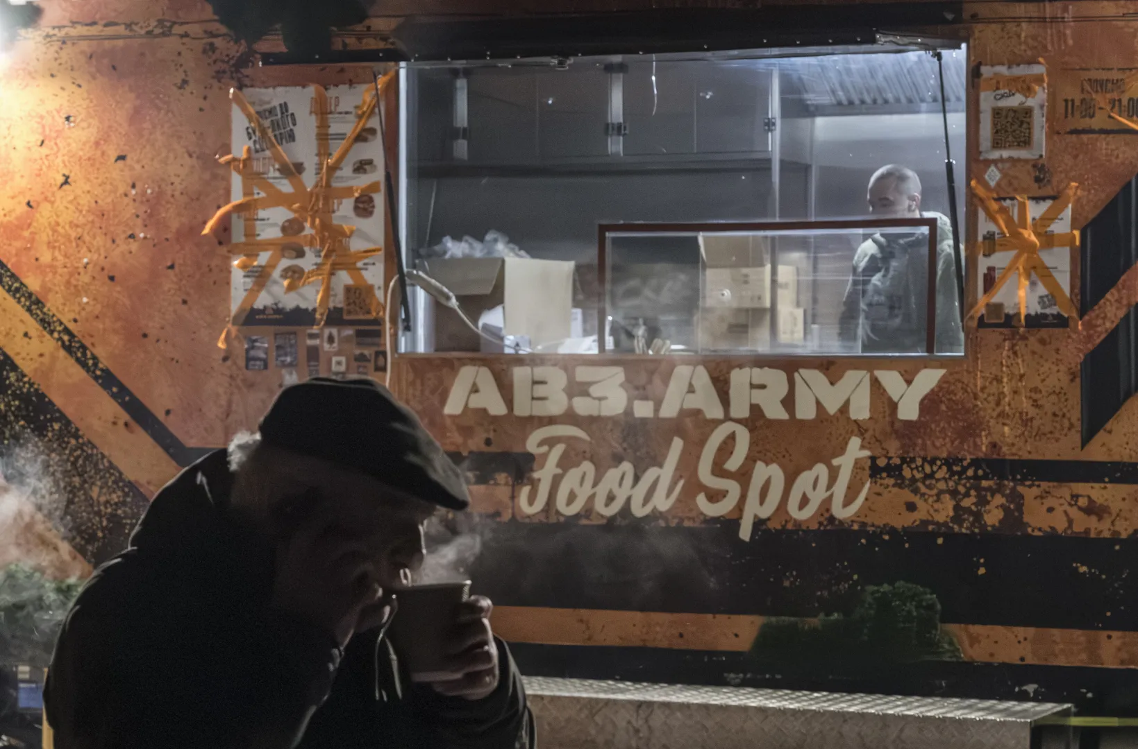 Mieszkaniec Kijowa ogrzewa się ciepłą herbatą Fot. PAP/EPA/MAXYM MARUSENKO