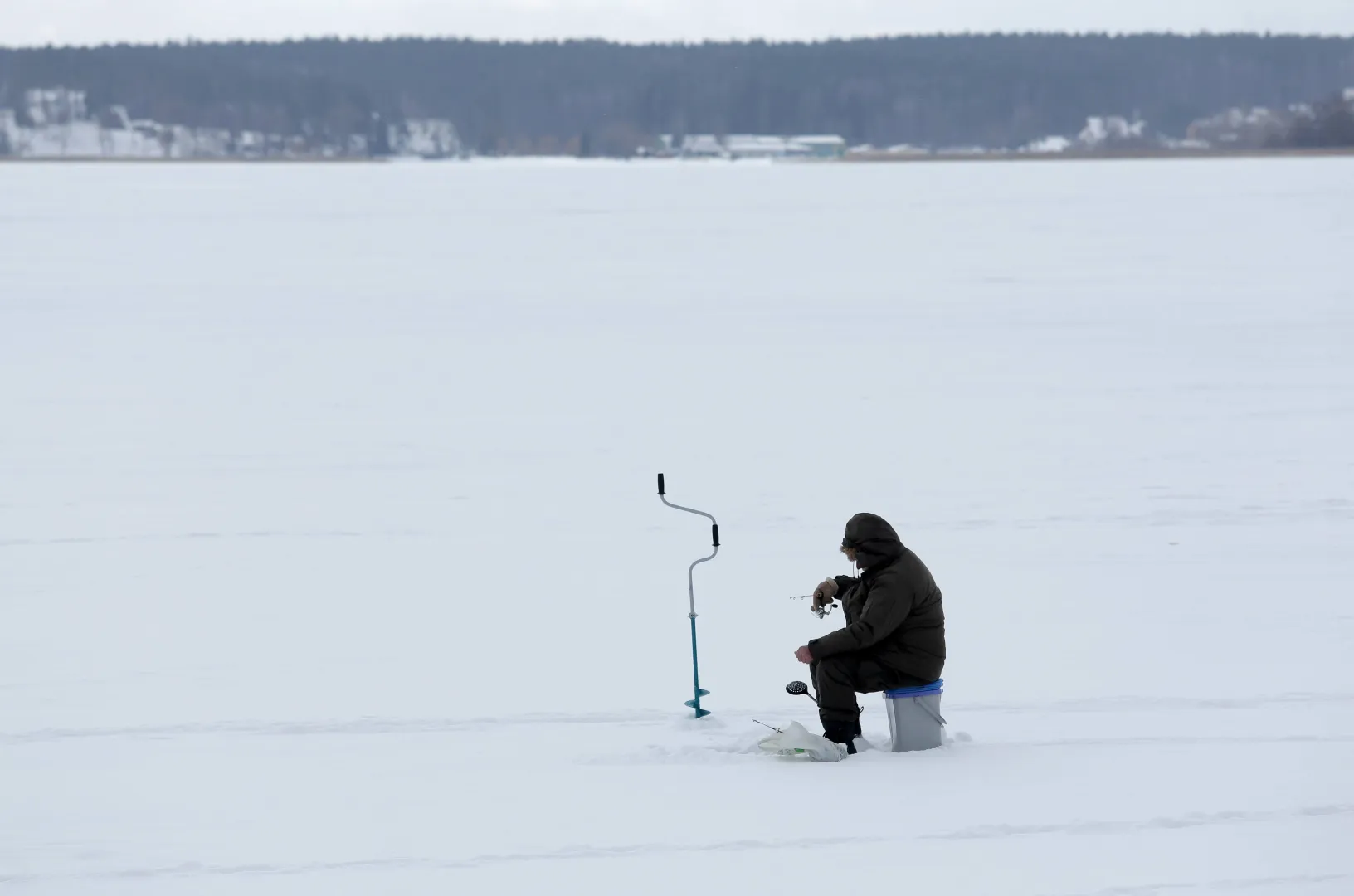 Wędkarz podlodowy na zamarzniętym jeziorze Niegocin Fot. PAP/Tomasz Waszczuk