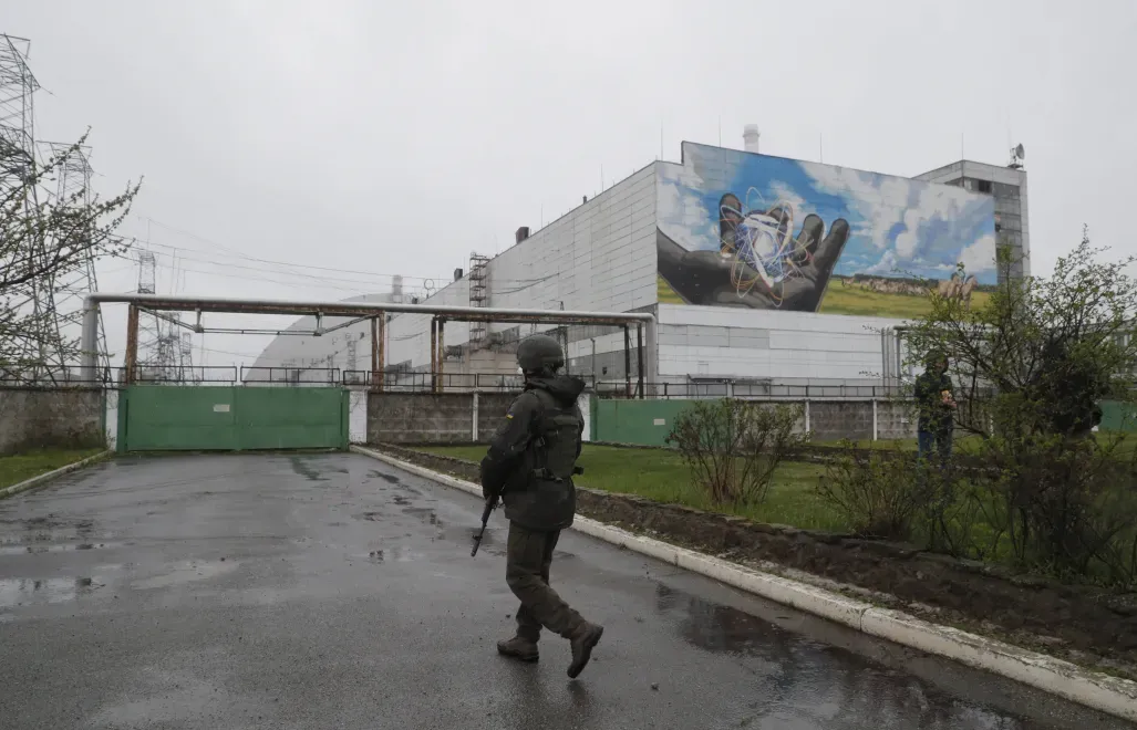 Uzbrojony bojownik Gwardii Narodowej maszeruje przed elektrownią jądrową w Czarnobylu Fot. PAP/EPA/SERGEY DOLZHENKO