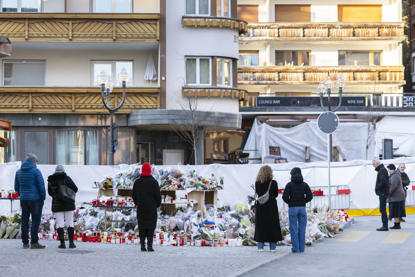 Kwiaty i znicze przed miejscem tragedii w Crans-Montanie, fot. PAP/EPA/KEYSTONE/CYRIL ZINGARO
