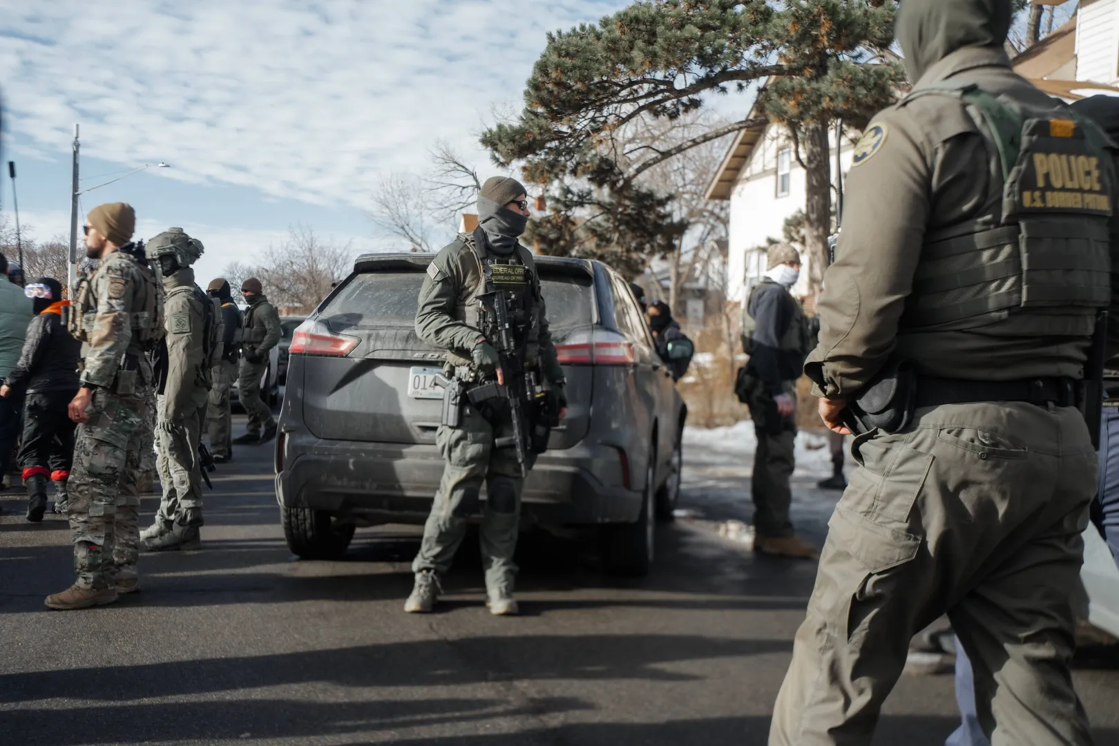 Agent ICE (w środku) oraz funkcjonariusze jednostki Border Patrol w Minneapolis, fot. PAP/EPA/OLGA FEDOROVA