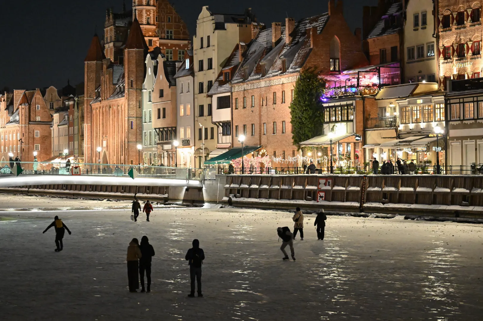 Spacerowicze i łyżwiarze na zamarzniętej rzece Motławie w Gdańsku. Fot. PAP/Adam Warżawa