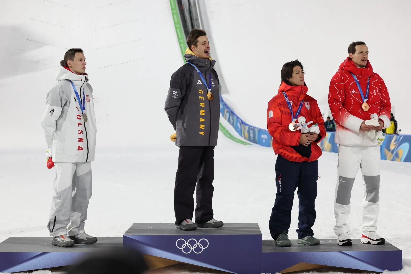 Zimowe Igrzyska Olimpijskie - Mediolan i Cortina d’Ampezzo 2026. Od lewej: Polak Kacper Tomasiak (srebro), Niemiec Philipp Raimund (złoto) oraz Japończyk Ren Nikaido i Szwajcar Gregor Deschwanden ex aequo z brązowymi medalami. Fot. PAP/Grzegorz Momot