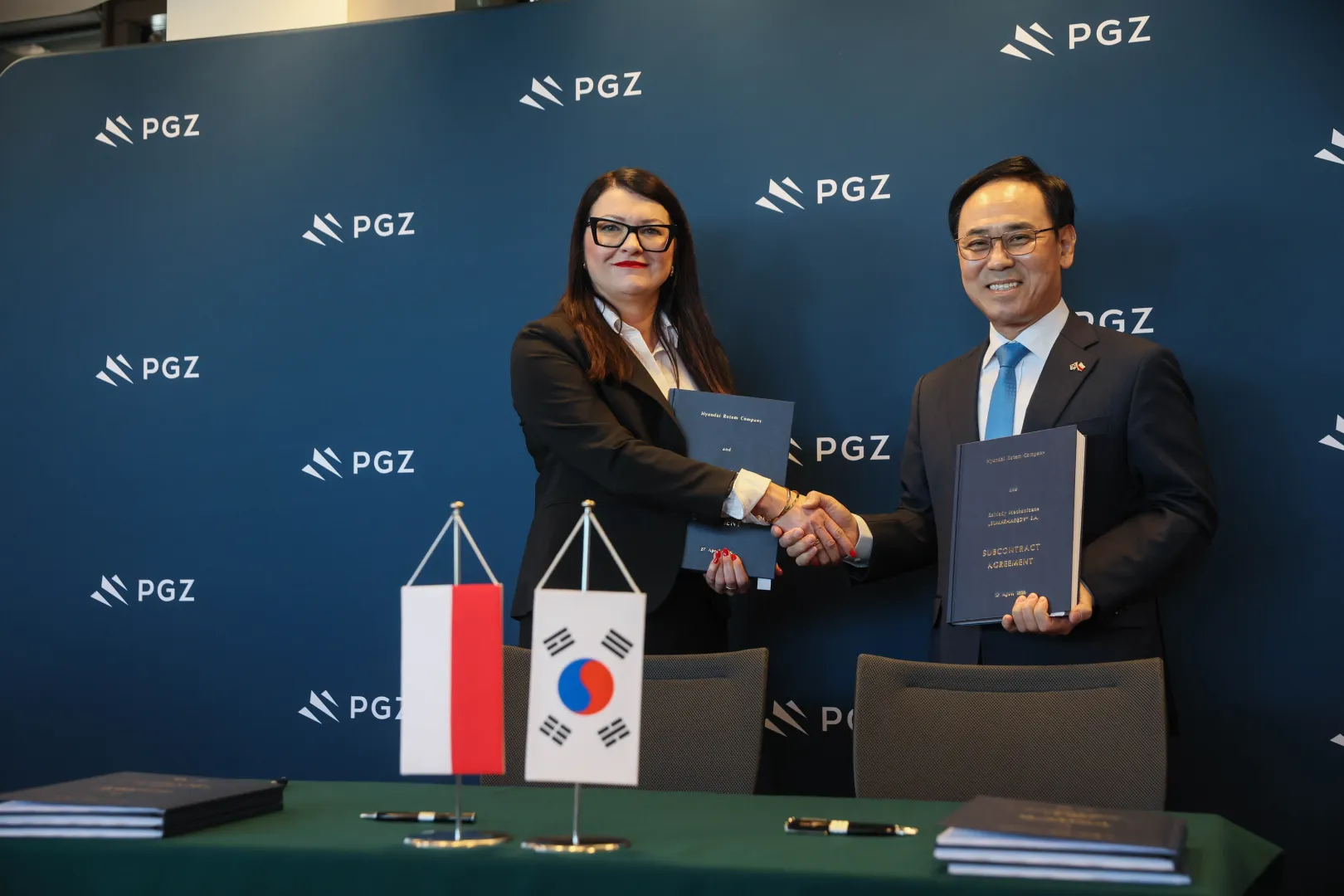 Голова правління компанії Bumar-Łabędy Моніка Кручек (ліворуч) та генеральний директор компанії Hyundai Rotem Company Йонг-бе Лі (праворуч) під час підписання субпідрядного договору між компанією Bumar-Łabędy та компанією Hyundai Rotem Company у Варшаві. Fot. PAP/Leszek Szymański