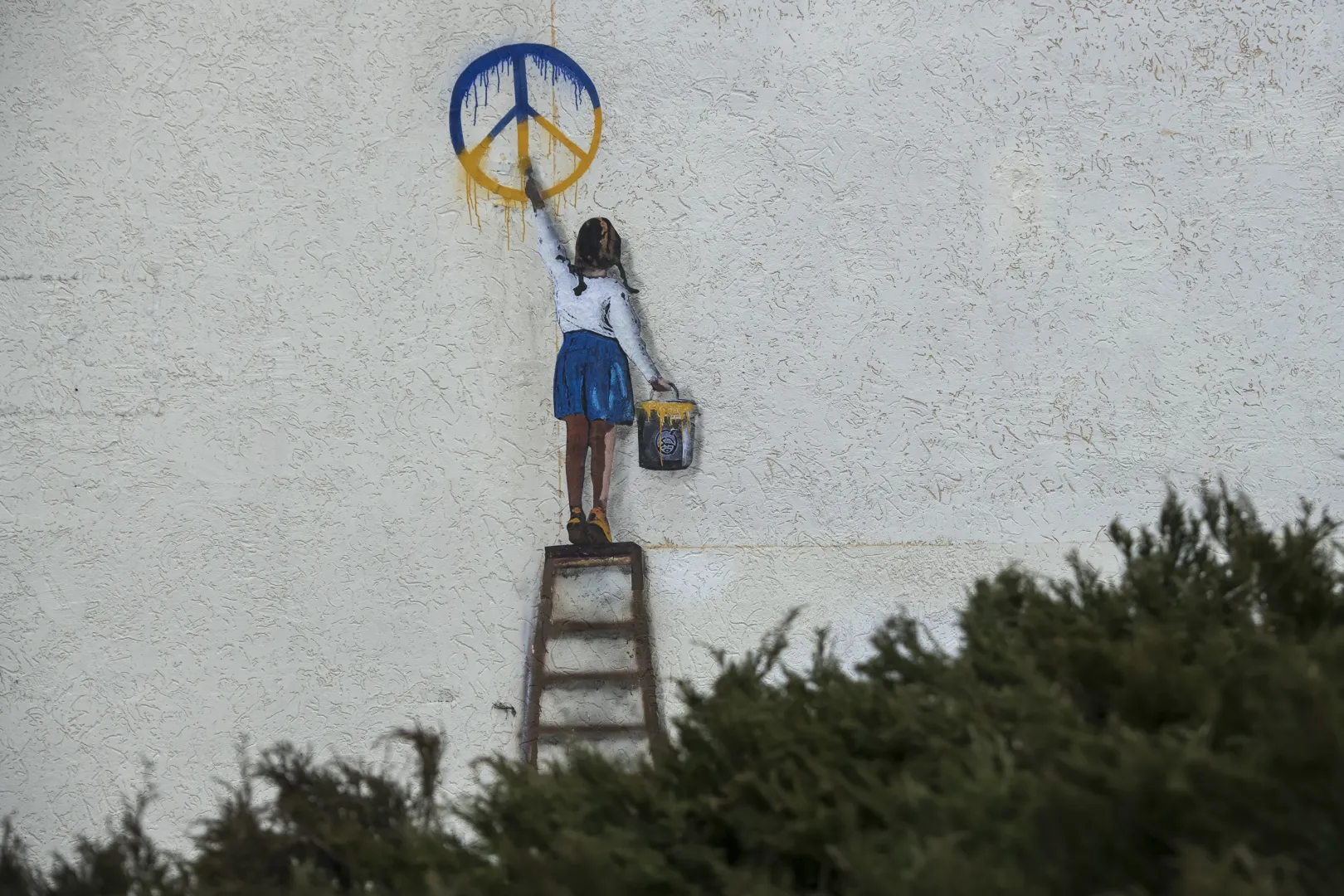 Graffiti autorstwa włoskiego artysty TV Boya na murze budynku w Buczy. Fot. PAP/	Vladyslav Musiienko