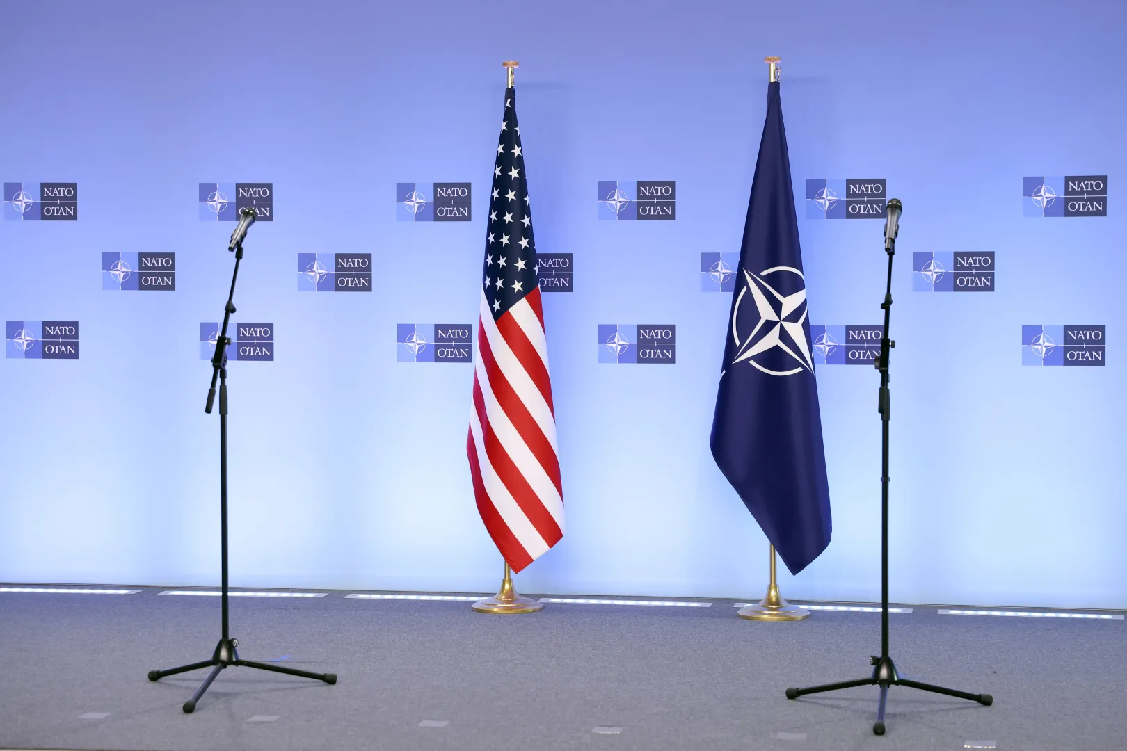 На фотографії зображені прапори НАТО та США перед початком пресконференції. Фотоілюстрація. Fot. PAP/EPA/KENZO TRIBOUILLARD / POOL