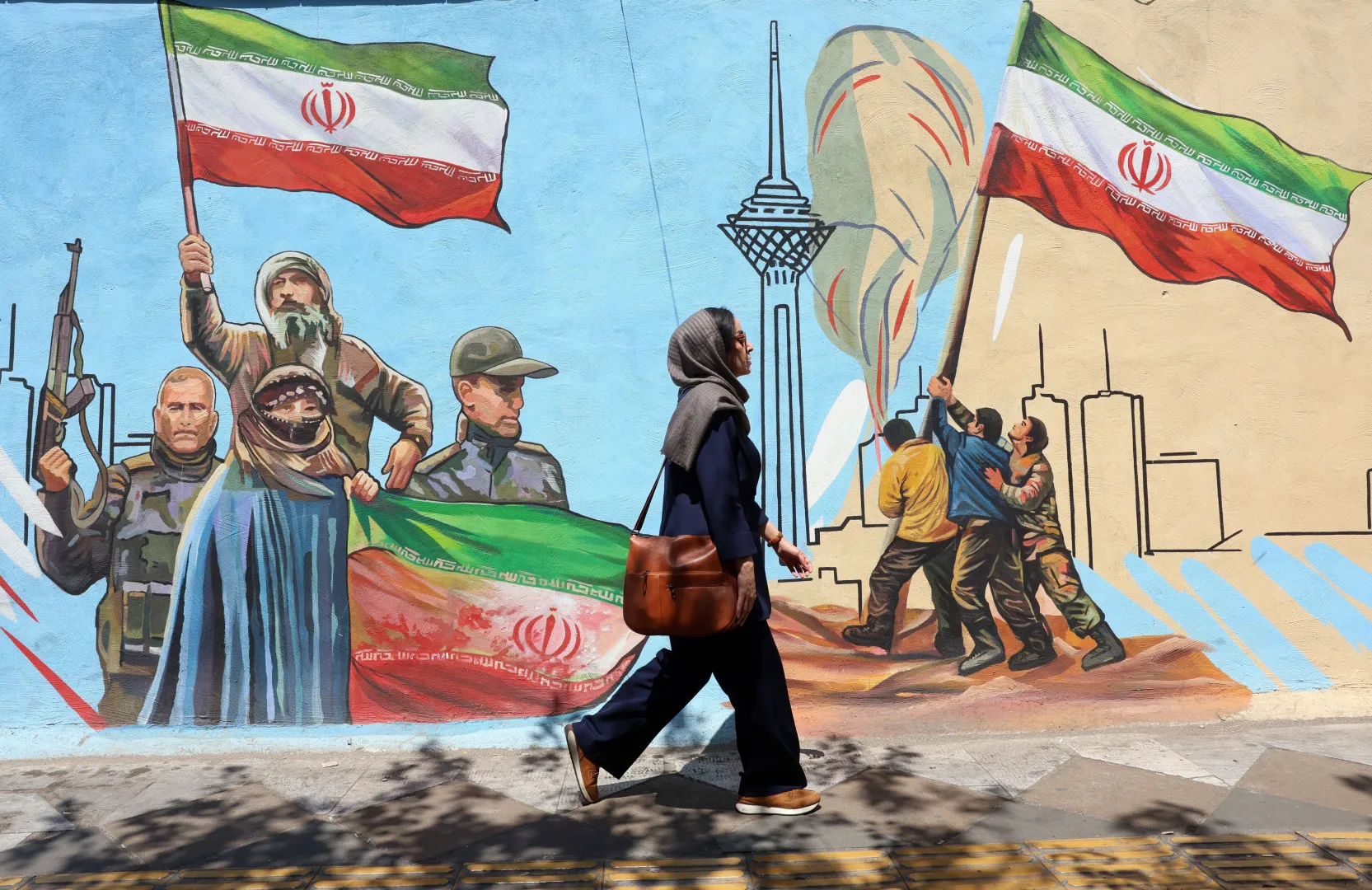 Iranka przechodzi obok muralu na ulicy w Teheranie Fot. PAP/EPA/ABEDIN TAHERKENAREH