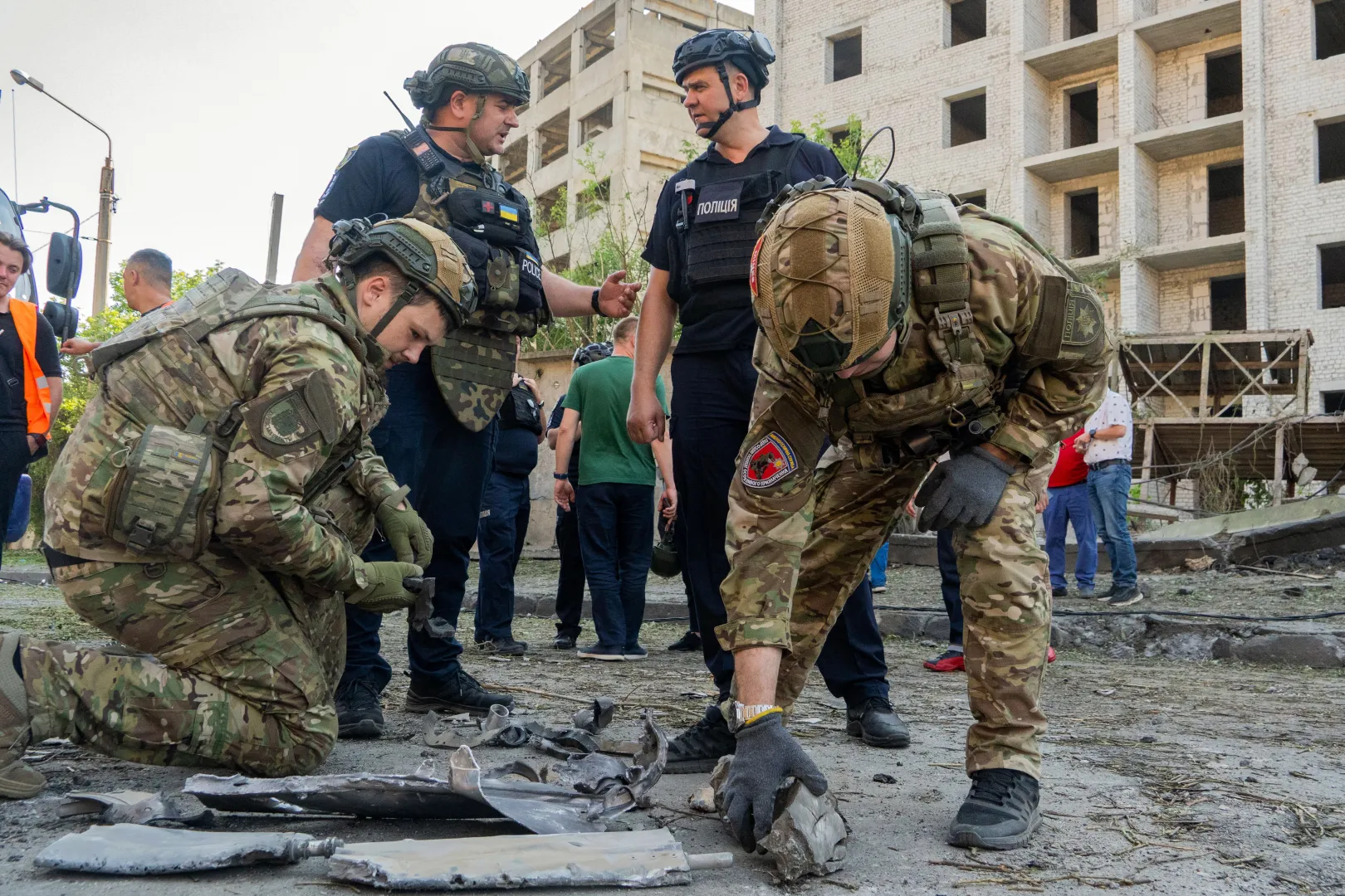 Saperzy zbierają fragmenty rosyjskiej lotniczej bomby kierowanej (KAB) w Charkowie. Fot. PAP/Mykola Kalyeniak