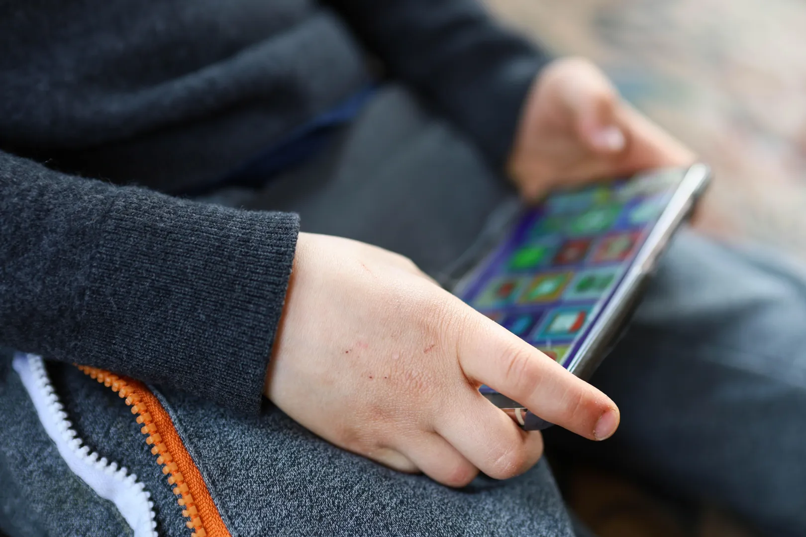 Smartfon w rękach dziecka - zdjęcie ilustracyjne. Fot. PAP/Szymon Pulcyn