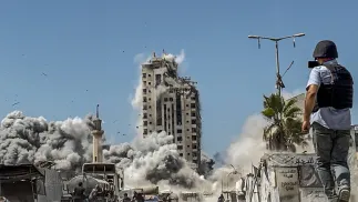 Dziennikarz nagrywa ostrzał w Strefie Gazy Fot. PAP/EPA/MOHAMMED SABER