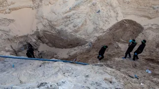 Członkowie Hamasu wydobywają ciało izraelskiego zakładnika z tunelu Fot. PAP/EPA/HAITHAM IMAD