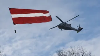 Śmigłowiec UH-60M Black Hawk Łotewskich Sił Powietrznych i flaga narodowa Fot. PAP/EPA/TOMS KALNINS